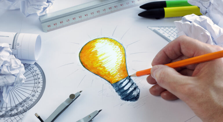 Designer drawing a light bulb, concept for brainstorming and inspiration