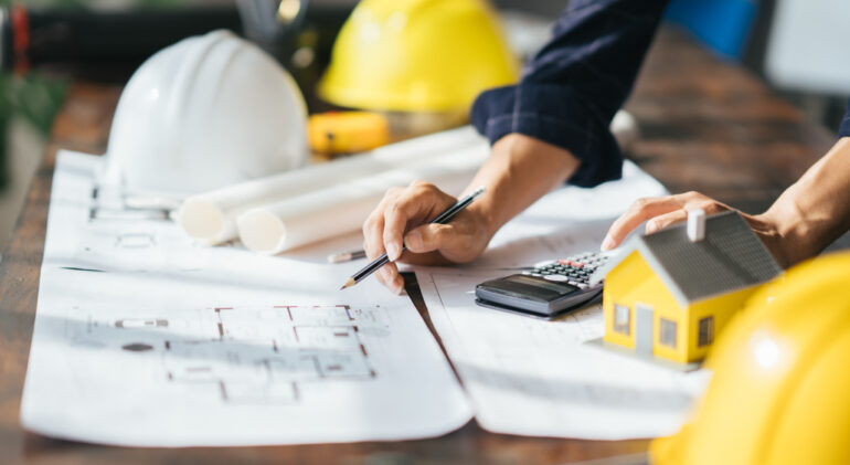 Cropped shot of Professional architect working at his desk, measuring and estimating the house project.